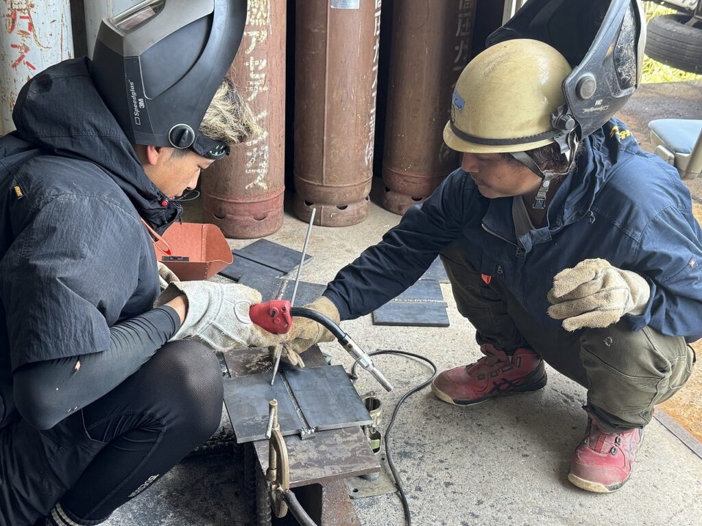 溶接作業の体験をしている見学者